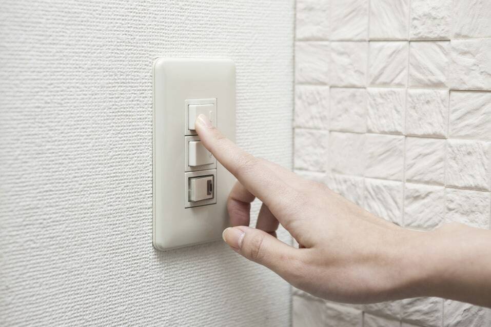 Ein Finger, der ein Licht einschaltet, symbolisiert den Übergang zu einer unabhängigen Vermögensverwaltung für eine bessere Vergütung.