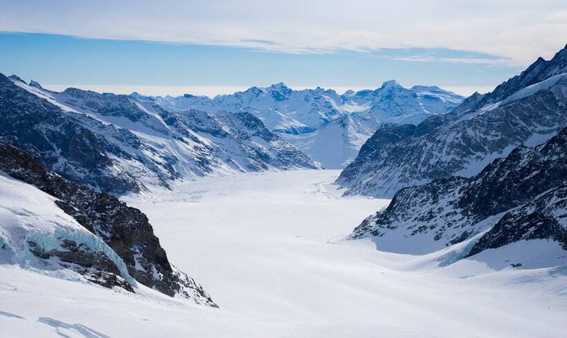 A breathtaking aerial view of the snow-covered Swiss Alps, symbolizing the strength and stability of the Swiss wealth managers overview.
