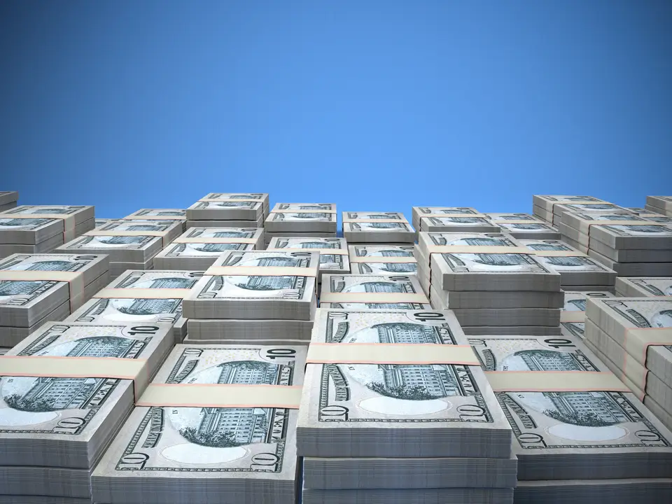 Stacks of 10-dollar bills under a clear blue sky, symbolising wealth preservation, secure investments, and high-net-worth financial strategies.